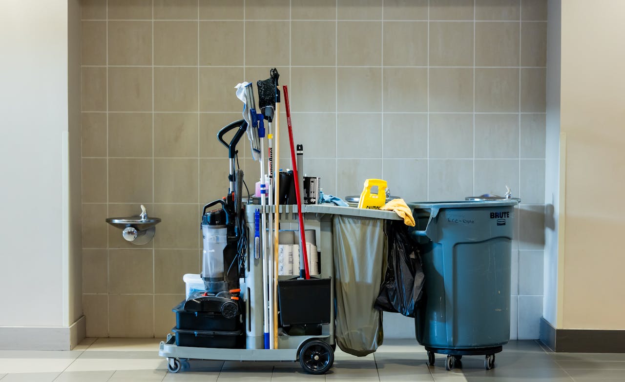 services-04 A comprehensive collection of professional cleaning tools on a cart in an indoor environment.